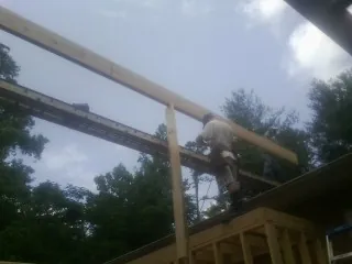 Carpenter setting a ridge beam over a new addition frame — Ice Dam Removal by Roofing Brothers in Buffalo Creek