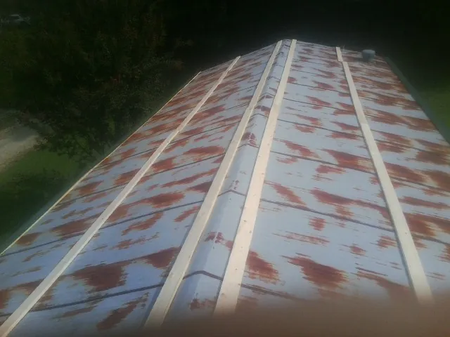 Rusted metal roof panels with new wood purlins before replacement — Storm Damage Roof Repair in Buffalo Creek by Roofing Brothers