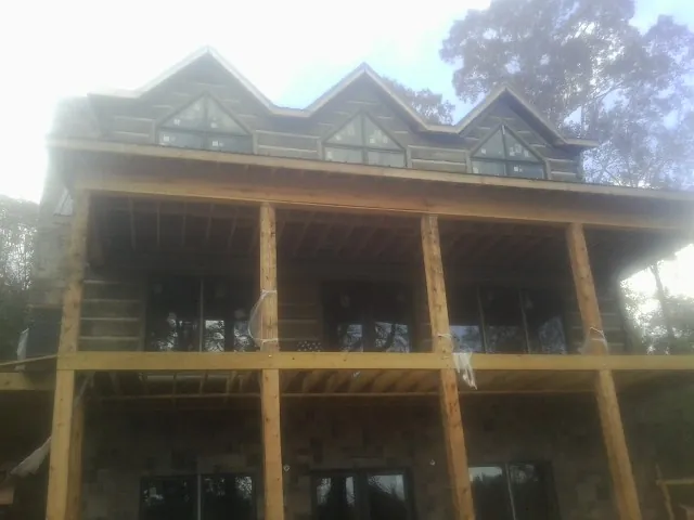 Dormers and porch framing on a large log home under construction in Buffalo Creek