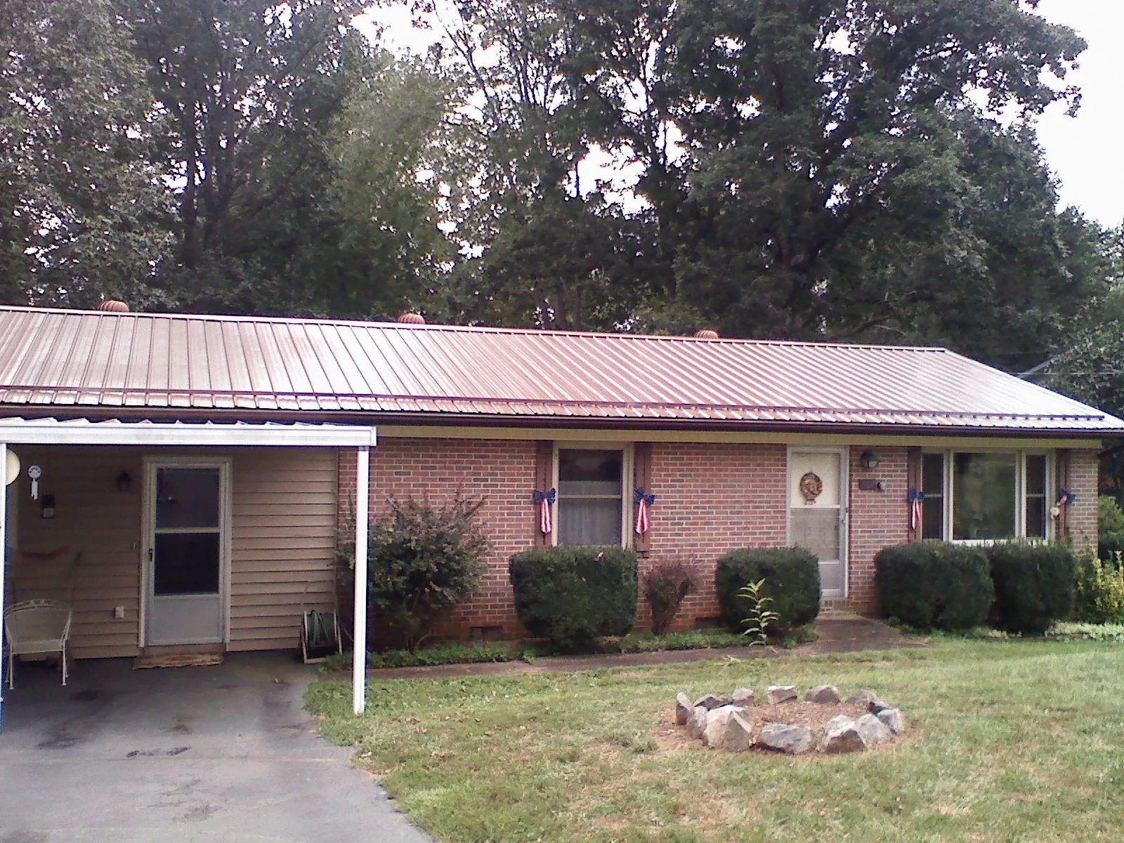 Bronze metal roof and carport on a brick ranch home — Roof Repair work by our crew in Buffalo Creek